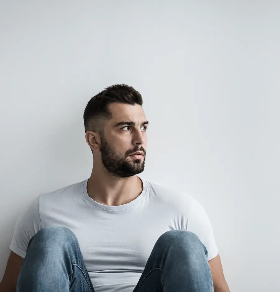 stressed man sitting against wall